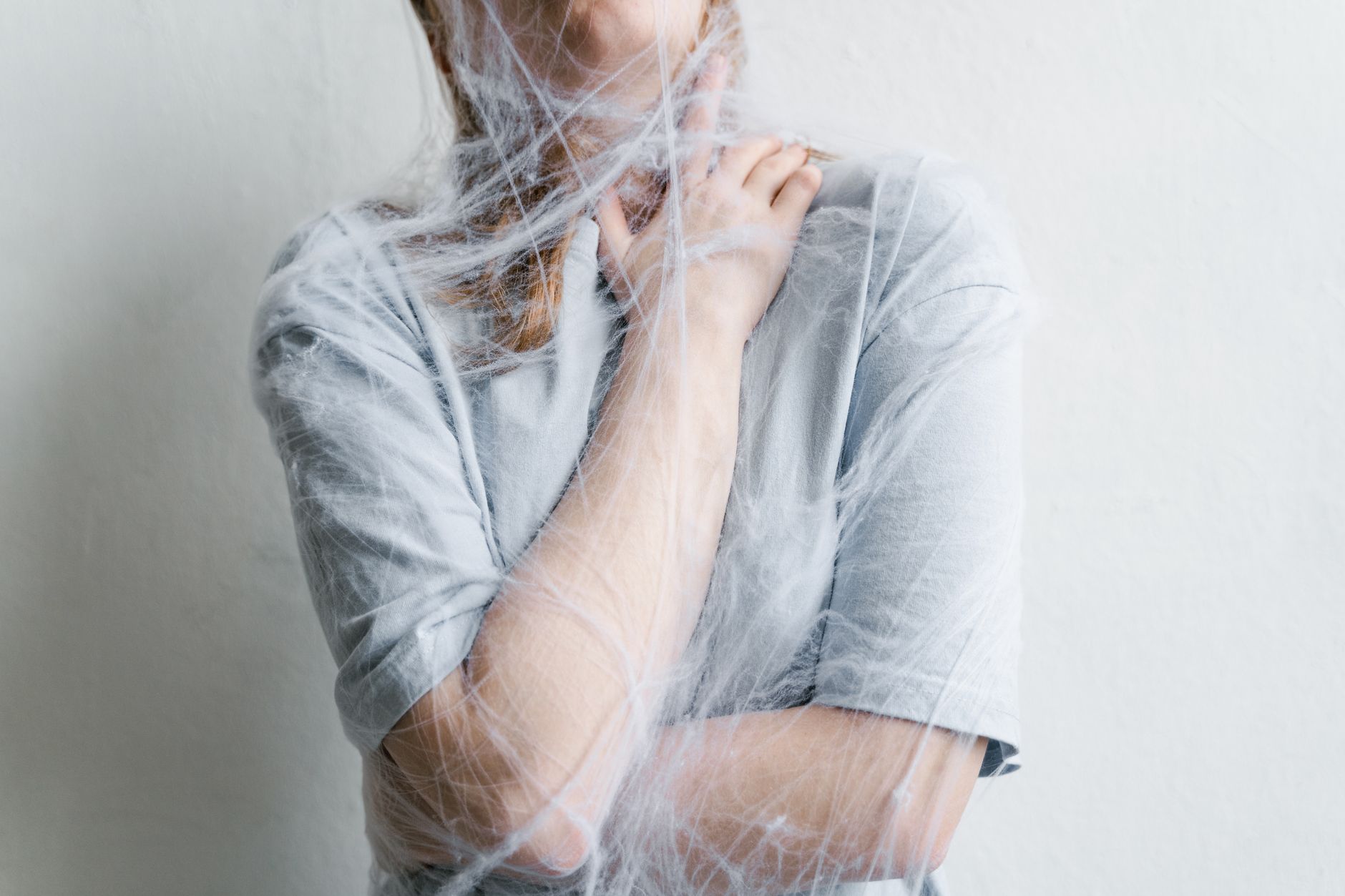 close up photo of a helpless woman trapped in a spider web
