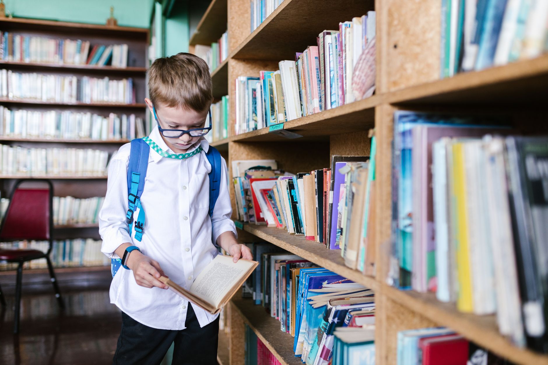 boy in school uniform reading a book